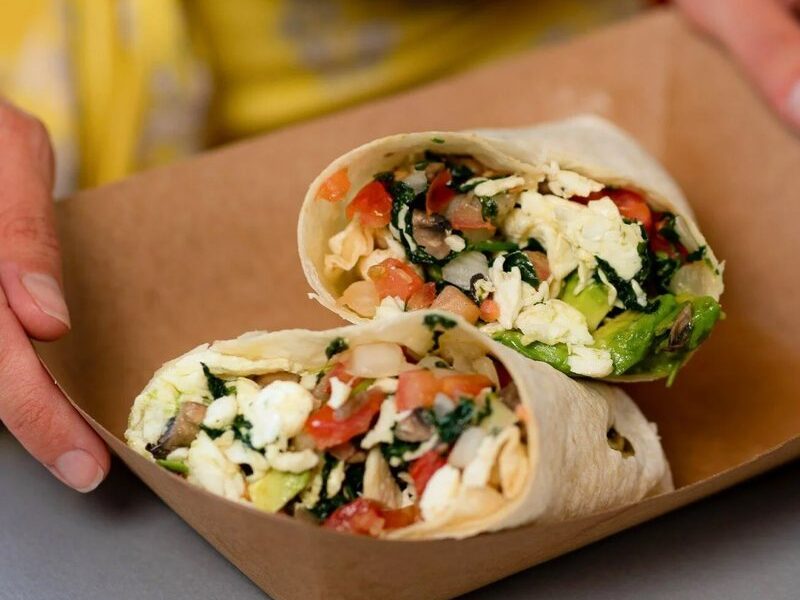 The Healthy Fresca Burrito cut in half, with egg whites, spinach, salsa fresca and avocado